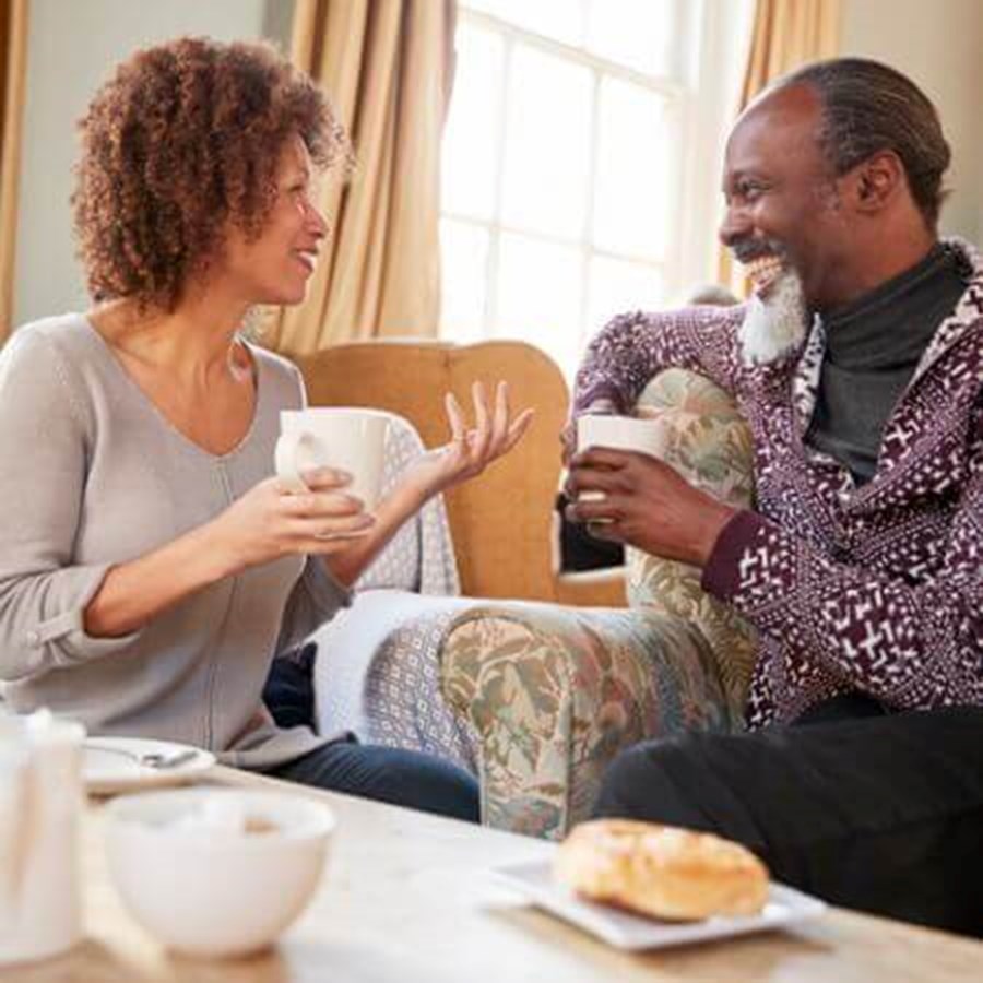 Middle Aged Couple Sitting Around Table In Coffee Shop