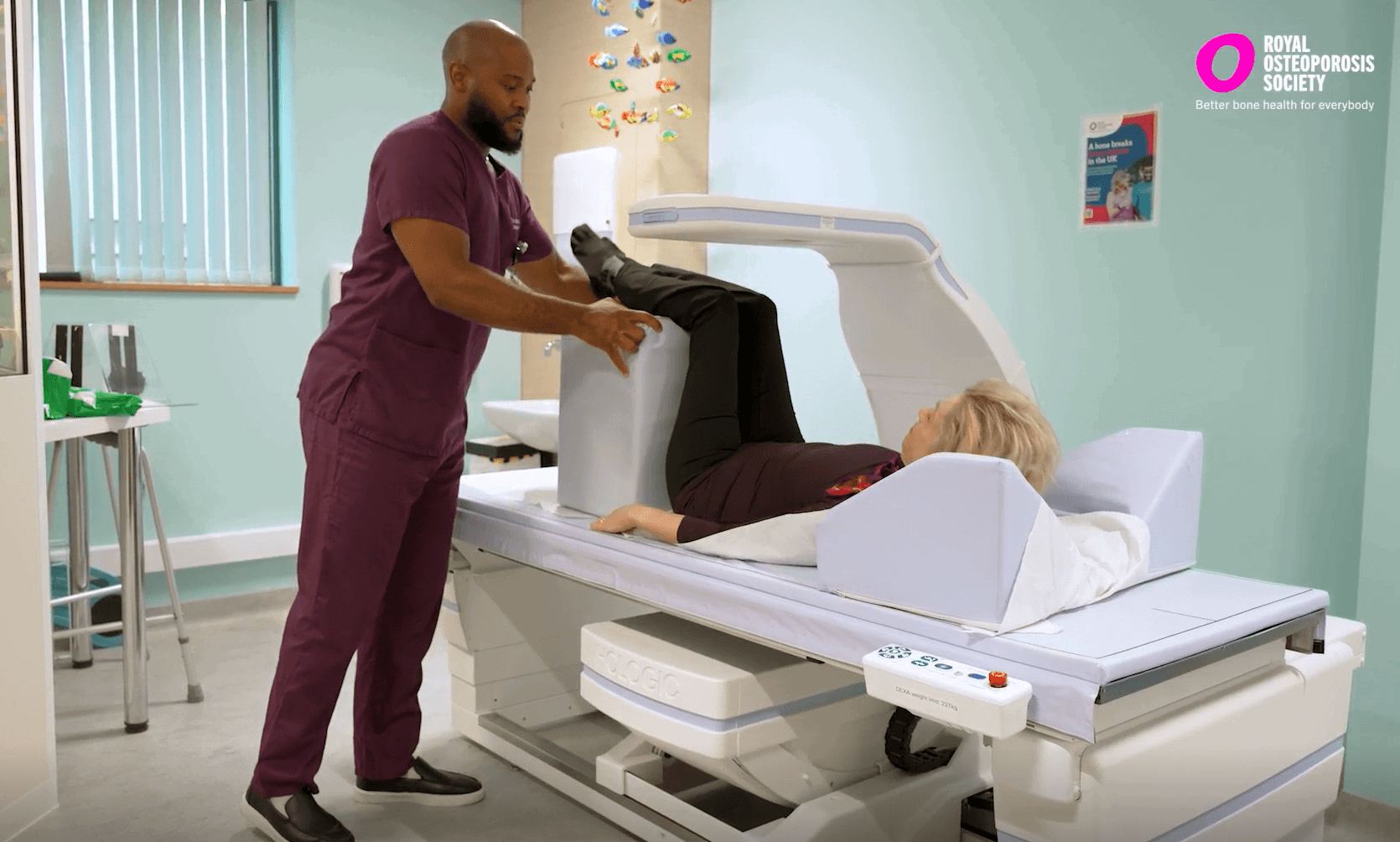 Radiographer positioning a woman for a bone density scan of the spine