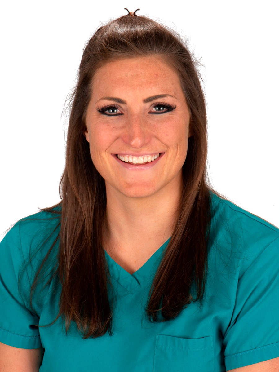 Picture of Emily Rose-Parfitt, a woman with brown hair smiling in nurses scrubs
