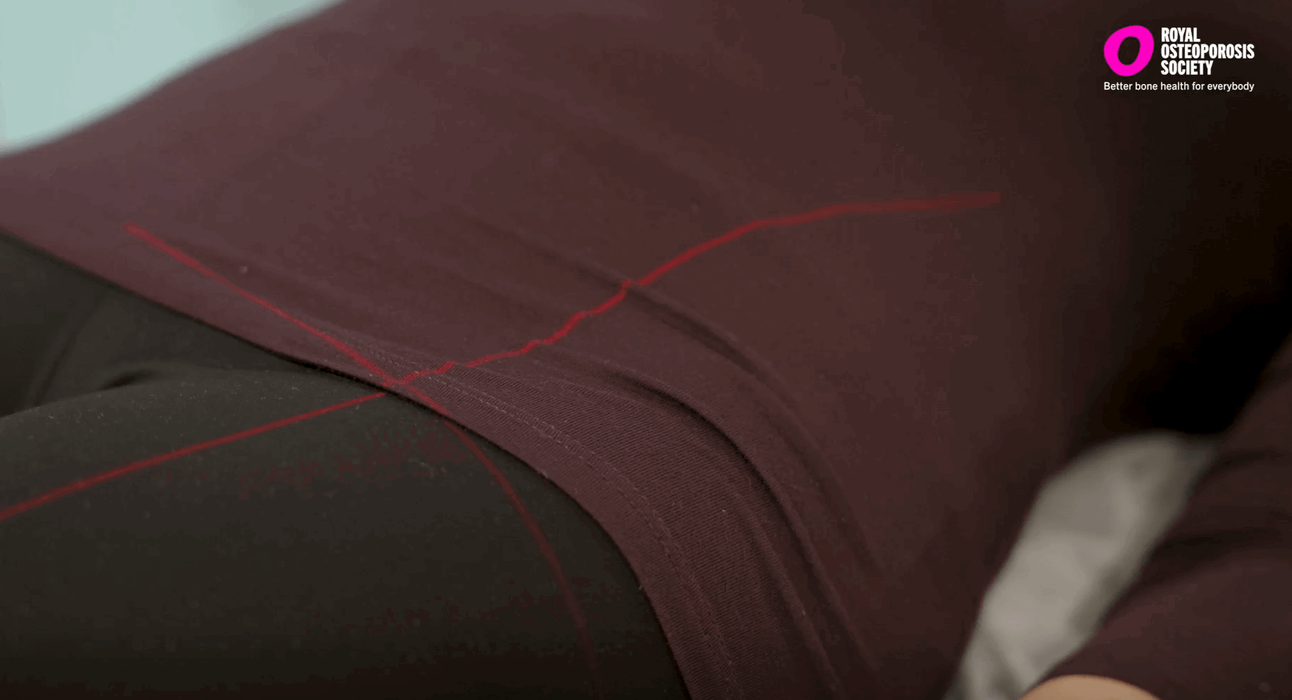 Red line of a bone density scanning machine shown across a woman's body