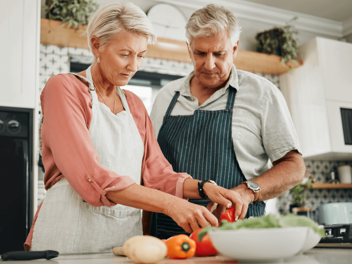 Couple chopping vegetables at the kitchen worktop