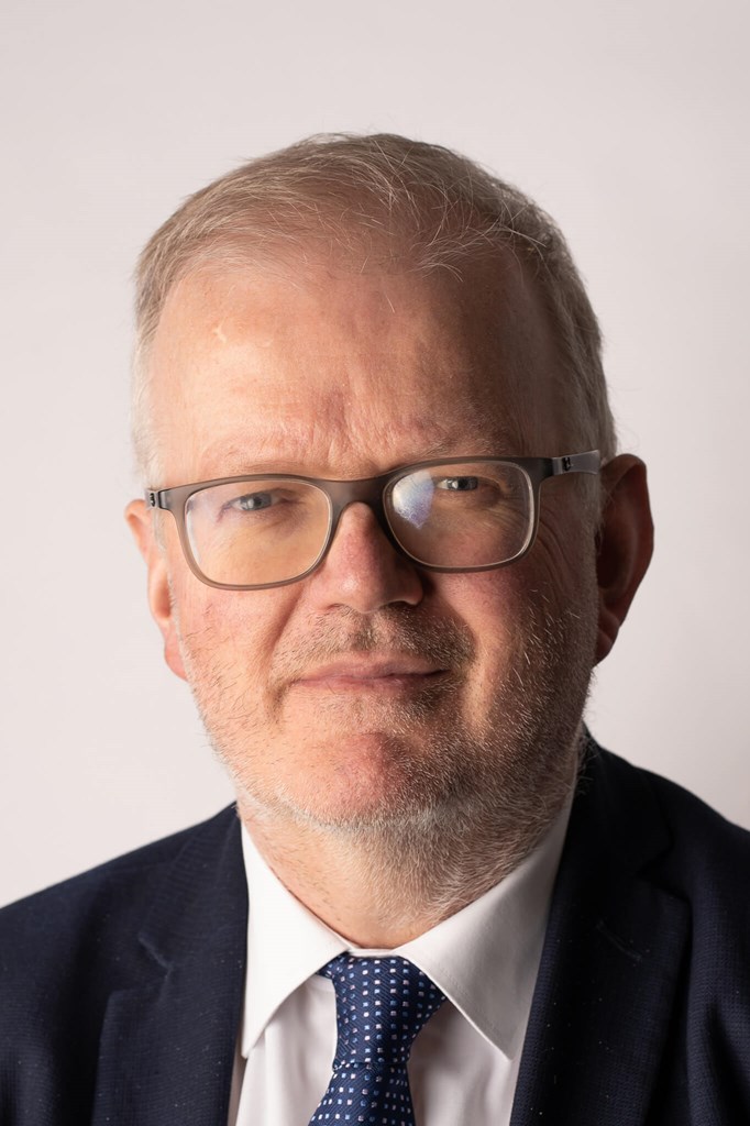 Richard Keen, a man with grey hair and glasses in a suit and tie