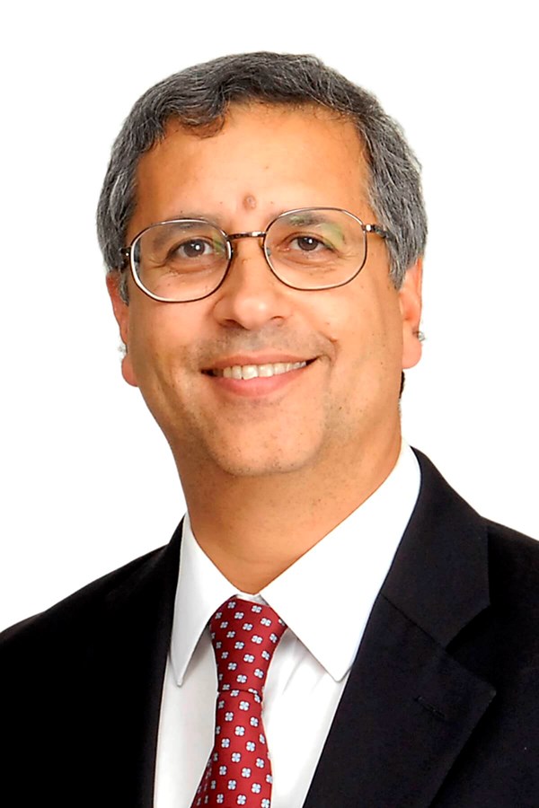 Photo of Cyrus Cooper, a man with grey hair and glasses in a suit and tie