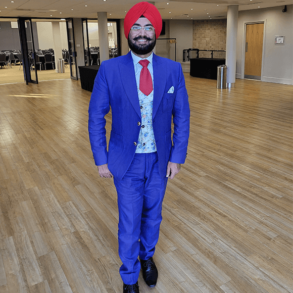 Dr Inderpal Singh standing in a conference centre for the FLS Conference in Wales