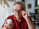 Senior man looking at some medication (1)
