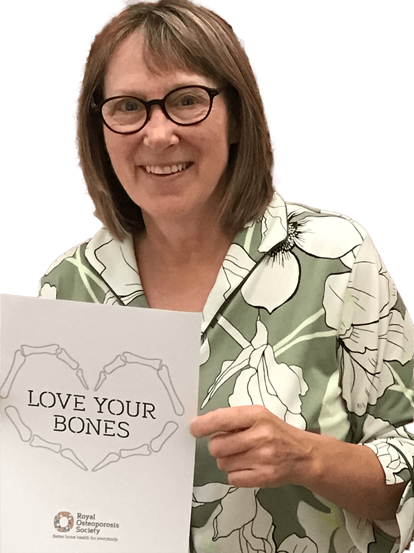 A member of the ROS Volunteer Engagement team holding up a piece of paper with the words love your bones in a heart