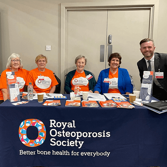 Four volunteers with the ROS CEO, Craig Jones sat behind a table at the FLS Conference in Wales